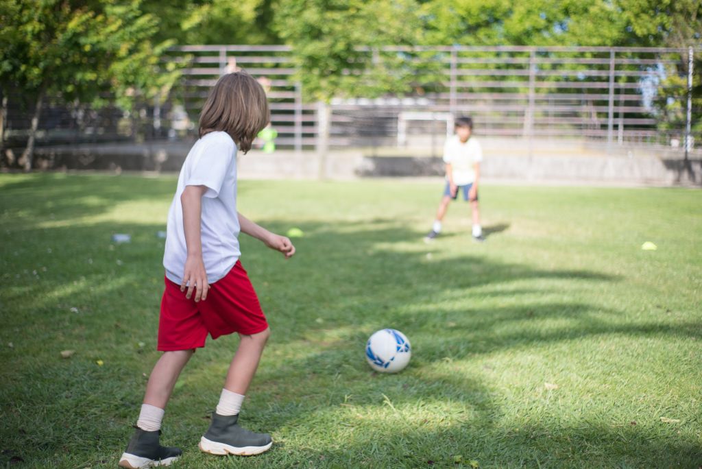 Enfants jouant au foot dans un jardin